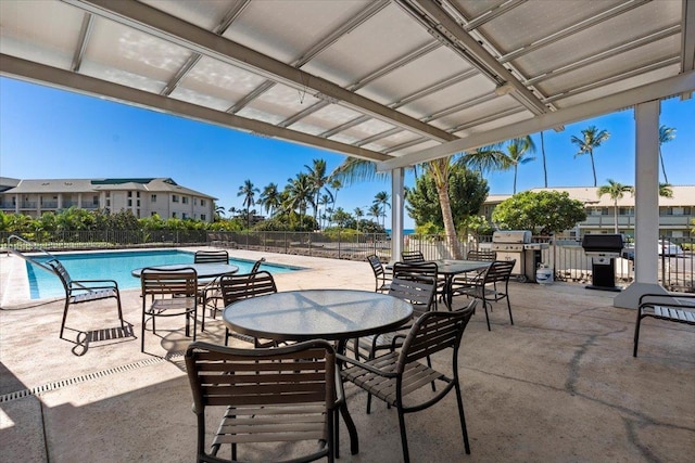 view of patio featuring a community pool, fence, and grilling area