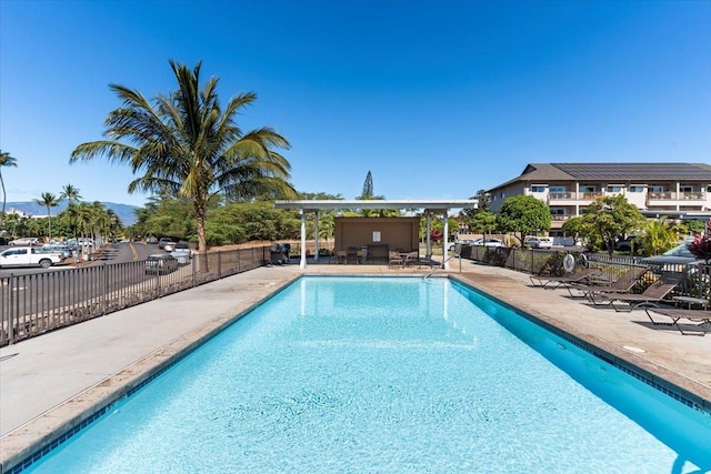 pool with a patio and fence