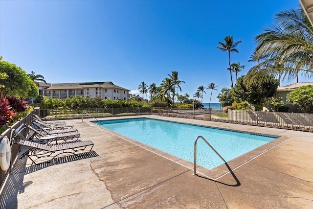 community pool with a patio and fence