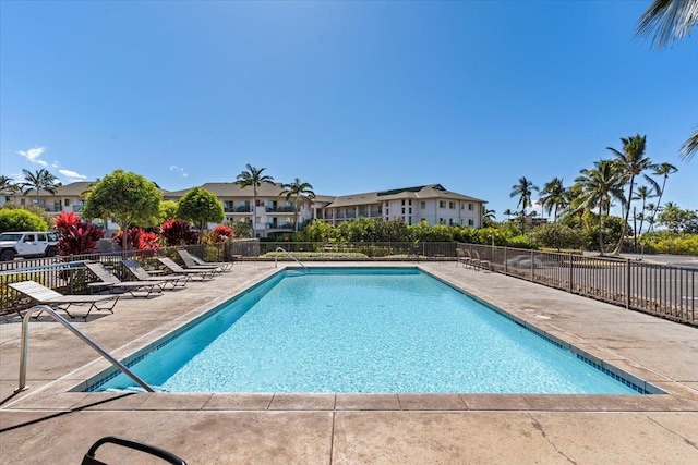 community pool with a patio and fence