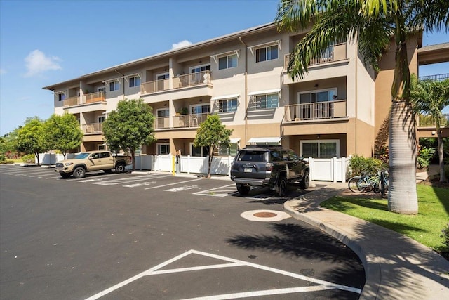 view of property featuring uncovered parking and fence