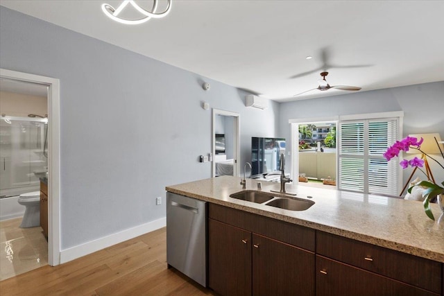 kitchen featuring a ceiling fan, baseboards, a sink, dishwasher, and light wood-type flooring