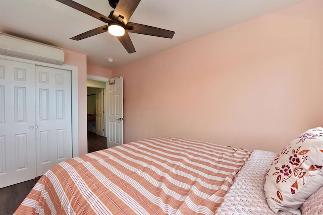 bedroom featuring dark hardwood / wood-style flooring, a wall unit AC, ceiling fan, and a closet