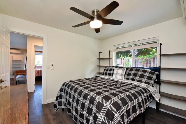 bedroom featuring dark wood-type flooring, a wall mounted AC, and ceiling fan