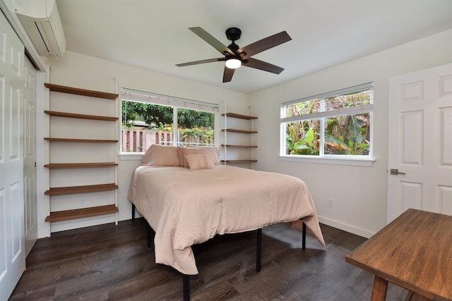 bedroom featuring dark wood-type flooring, multiple windows, a wall unit AC, and ceiling fan