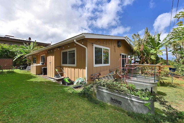 view of side of home with a yard