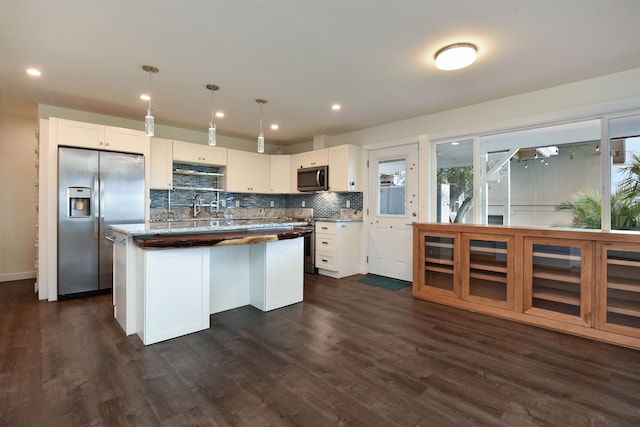 kitchen featuring white cabinetry, a center island, pendant lighting, and stainless steel appliances