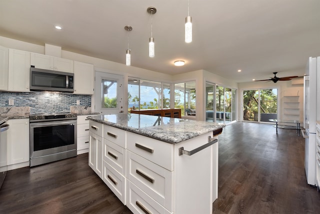 kitchen with stainless steel appliances, white cabinets, plenty of natural light, and pendant lighting