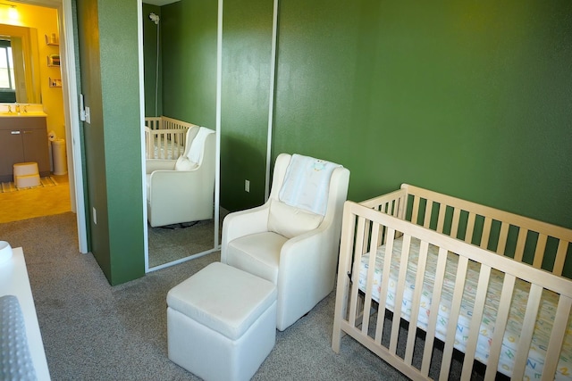 bedroom featuring a nursery area, a closet, and carpet