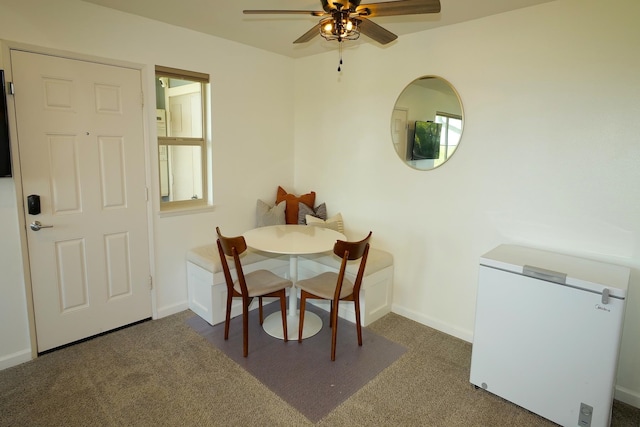 carpeted dining room featuring ceiling fan