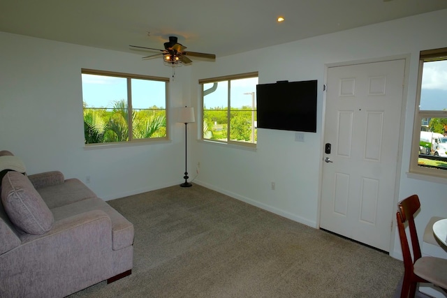 carpeted living room with ceiling fan and a healthy amount of sunlight