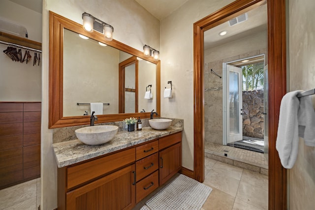 full bath with a sink, double vanity, a shower stall, and visible vents