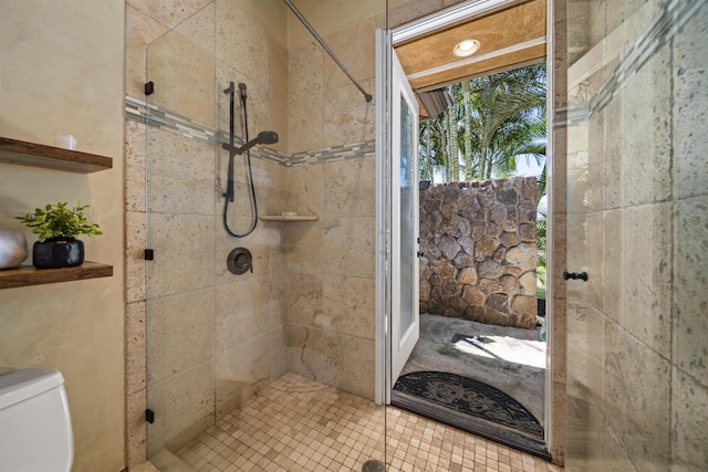 bathroom with a shower stall and toilet