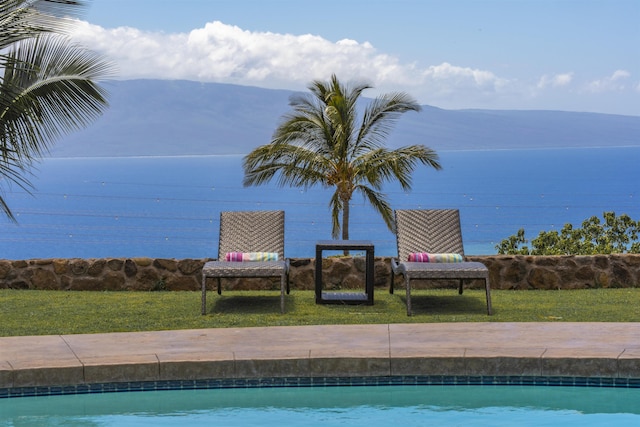 outdoor pool with a yard and a mountain view