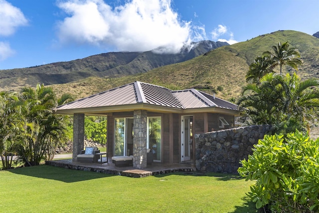 exterior space with a mountain view, a yard, and metal roof