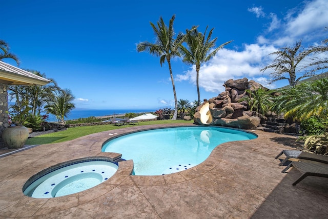 view of swimming pool with a patio, a water slide, and a pool with connected hot tub