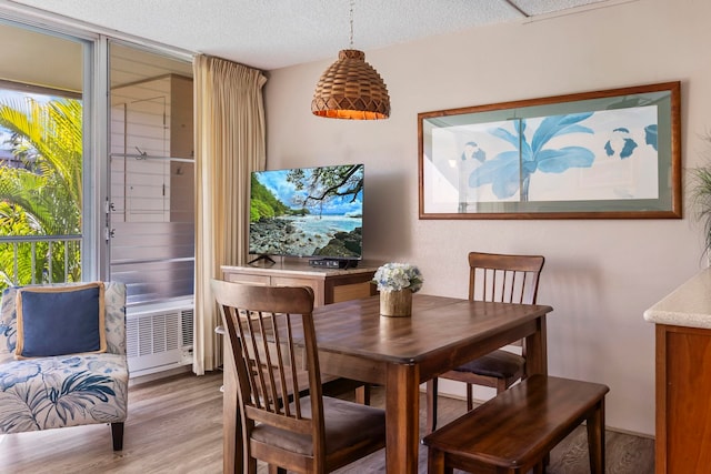 dining area featuring light hardwood / wood-style flooring and a textured ceiling