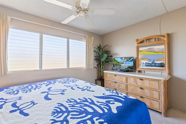 bedroom with ceiling fan, light colored carpet, and a textured ceiling