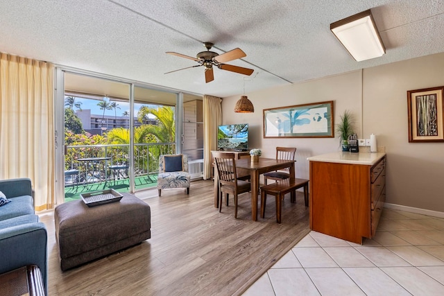 dining room featuring floor to ceiling windows, a textured ceiling, ceiling fan, and light tile patterned flooring