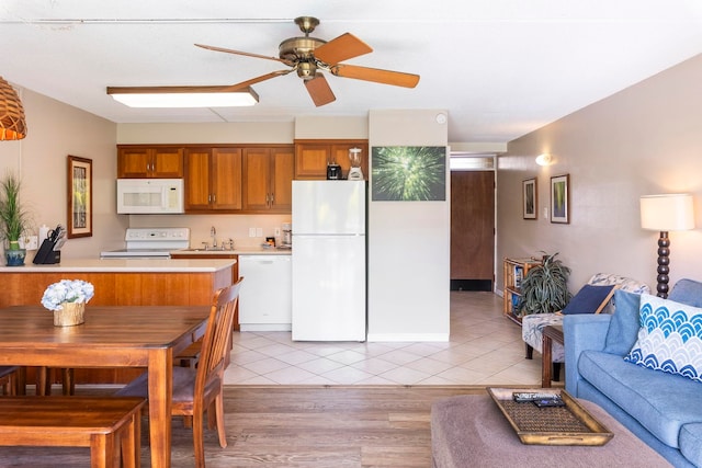 kitchen with ceiling fan, sink, light hardwood / wood-style floors, and white appliances