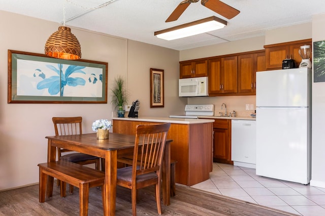 kitchen with pendant lighting, white appliances, sink, ceiling fan, and kitchen peninsula