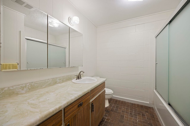 full bathroom with vanity, enclosed tub / shower combo, and toilet