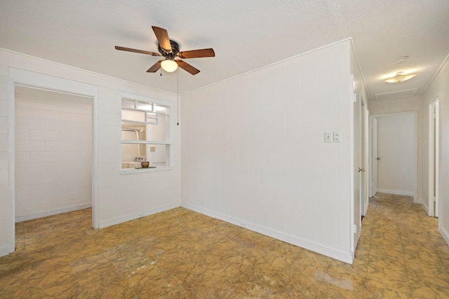 empty room with ceiling fan and a textured ceiling