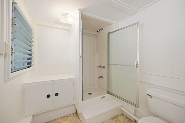 bathroom with toilet and a shower with door