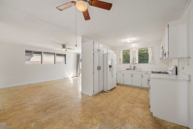 kitchen with a textured ceiling, white appliances, ceiling fan, sink, and white cabinetry