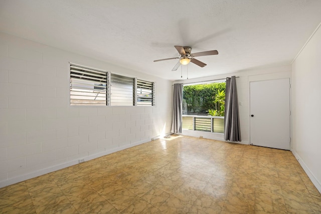 empty room with ceiling fan, plenty of natural light, and a textured ceiling