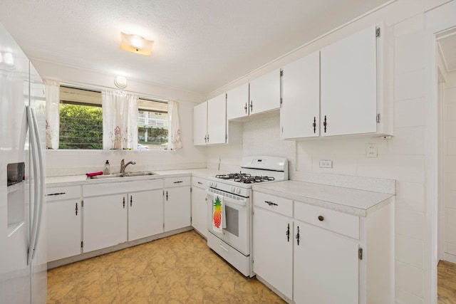 kitchen with a textured ceiling, white cabinetry, sink, and white appliances