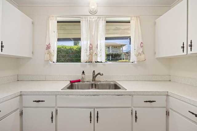 kitchen with white cabinetry, sink, and tasteful backsplash