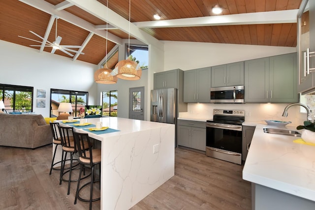 kitchen featuring hardwood / wood-style floors, appliances with stainless steel finishes, wood ceiling, and beam ceiling