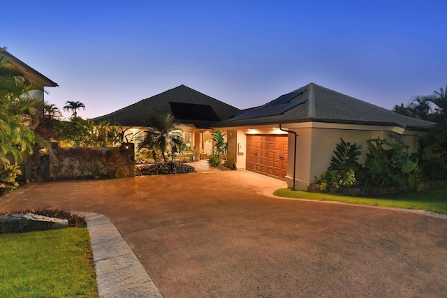 104 Woodrose Pl, Lahaina, HI 96761 - view of front of house with an attached garage, driveway, roof mounted solar panels, and stucco siding
