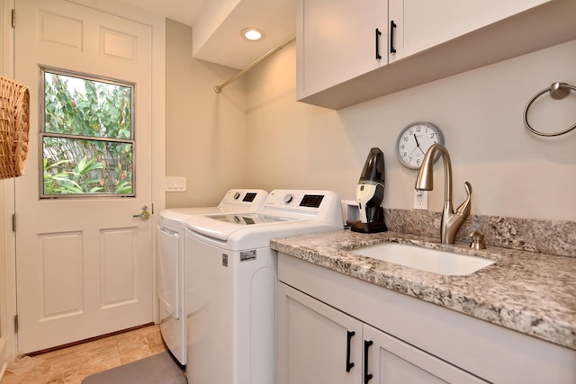 washroom with cabinets, sink, and separate washer and dryer