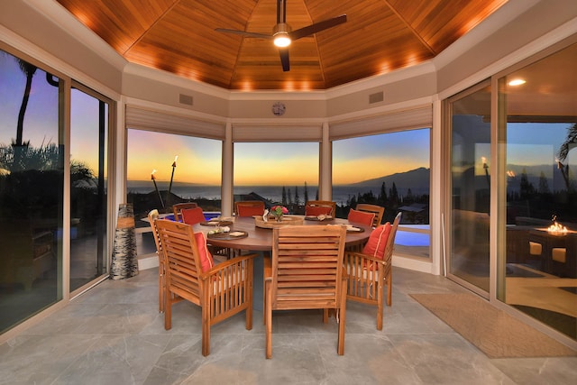 sunroom featuring wood ceiling, a tray ceiling, and ceiling fan