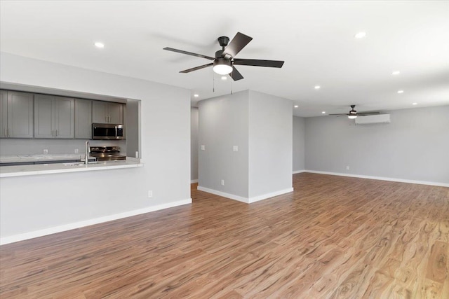 139 Mehani Pl, Kihei, HI 96753 - unfurnished living room with recessed lighting, light wood-style flooring, a wall unit AC, ceiling fan, and a sink