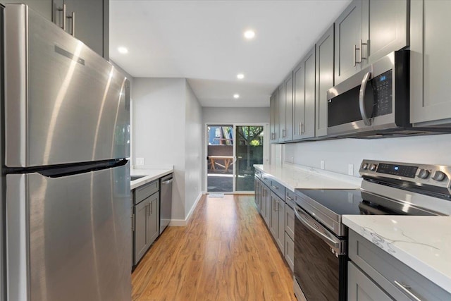 139 Mehani Pl, Kihei, HI 96753 - kitchen with baseboards, gray cabinetry, light stone countertops, light wood-style flooring, and stainless steel appliances