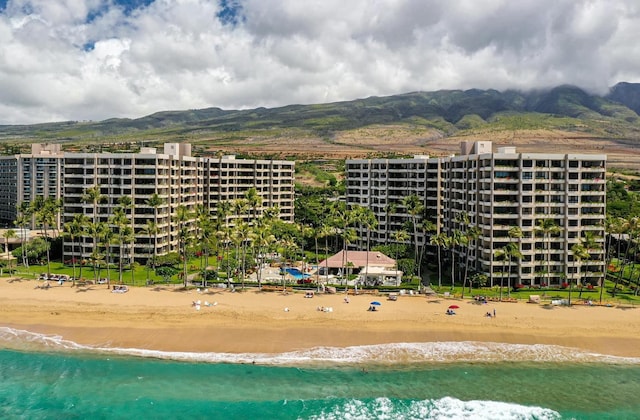 drone / aerial view featuring a view of the beach and a water and mountain view