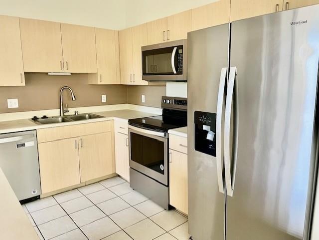 kitchen with stainless steel appliances, sink, and light tile patterned floors