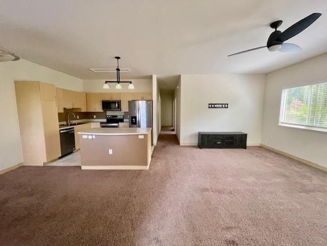 kitchen featuring a center island, light carpet, sink, appliances with stainless steel finishes, and decorative light fixtures