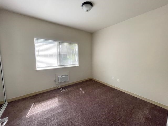 unfurnished room featuring carpet floors and a wall mounted AC