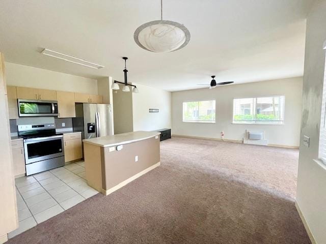 kitchen with hanging light fixtures, light colored carpet, appliances with stainless steel finishes, and a center island