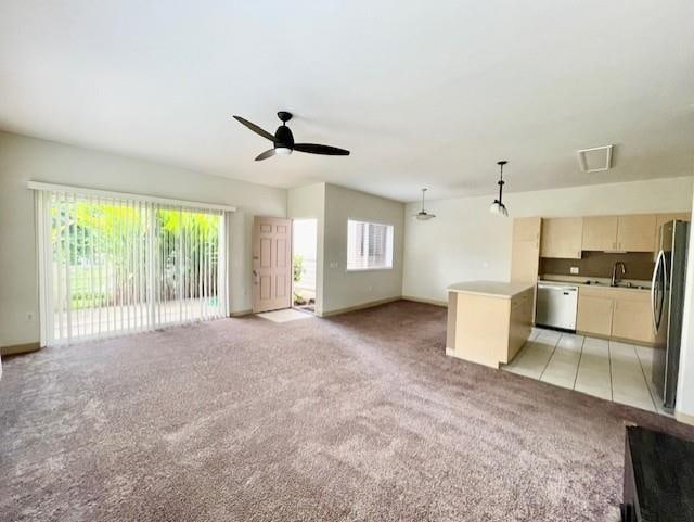 unfurnished living room featuring light carpet and ceiling fan