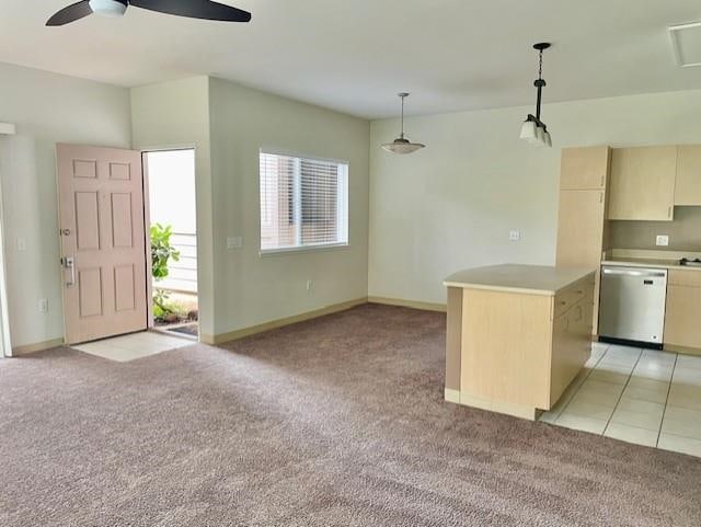 kitchen with light colored carpet, decorative light fixtures, a kitchen island, and stainless steel dishwasher