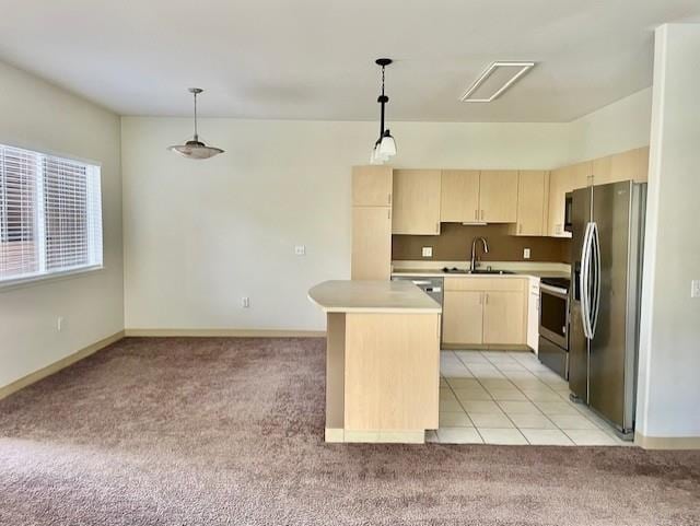 kitchen with sink, a kitchen island, decorative light fixtures, stainless steel appliances, and light carpet