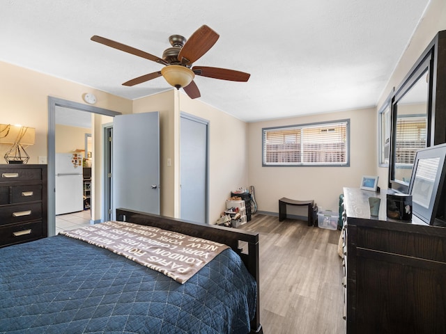3100 Mapu Pl, Kihei, HI 96753 - bedroom with freestanding refrigerator, light wood finished floors, and a ceiling fan