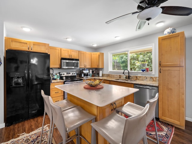 3100 Mapu Pl, Kihei, HI 96753 - kitchen with appliances with stainless steel finishes, dark wood finished floors, a kitchen bar, light countertops, and a center island