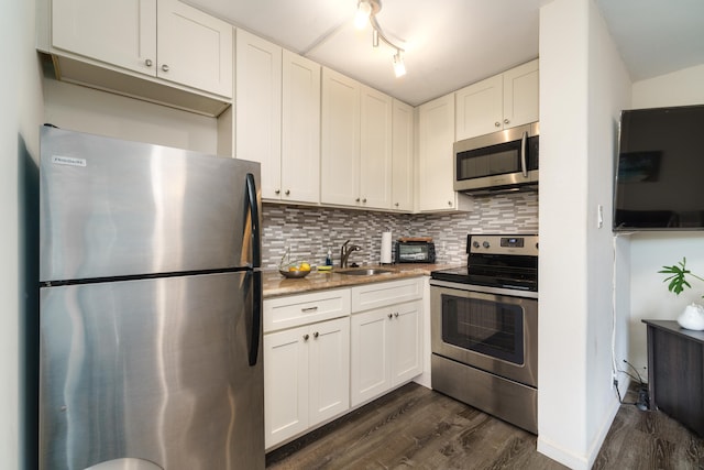 kitchen with decorative backsplash, stainless steel appliances, sink, dark hardwood / wood-style floors, and white cabinetry