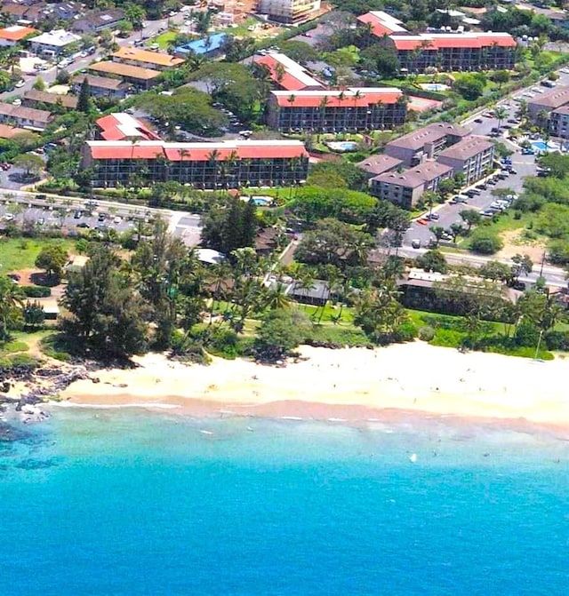 birds eye view of property with a water view and a beach view